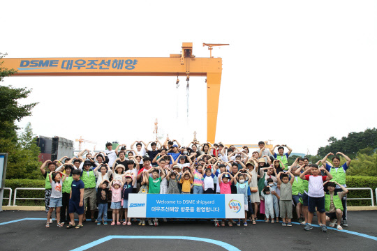 대우조선해양 새싹의 소리회 봉사단이 지난 25일 진행한 '새생명 바다축제' 행사에서 백혈병 소아암 환아와 가족들이 대우조선해양을 견학하고 기념촬영을 하고 있다. <대우조선해양 제공>